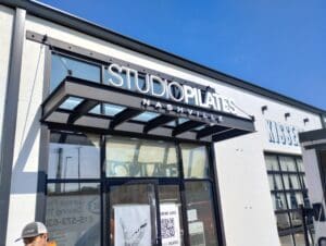 Exterior view of "studio pilates nashville" with storefront signage and glass facade on a sunny day.