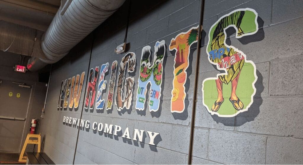 Colorful mural reading "Heights Brewing Company" on a gray brick wall, with each letter featuring unique designs.