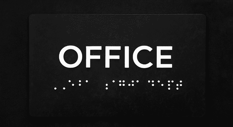 A black sign with the word "OFFICE" in white capital letters and Braille dots below it.