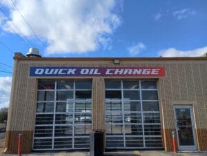 A one-story building with two garage doors and a sign reading "Quick Oil Change" above the entrance.