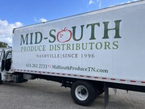 A white truck displaying the &ldquo;Mid-South Produce Distributors&rdquo; logo, contact information, and website, with "Nashville | Since 1996" printed under the company name.
