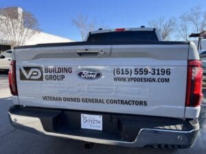 Tailgate of a Ford F-150 truck with VP Building Group branding, contact info, website, and text stating &ldquo;Veteran Owned General Contractors.&rdquo;.