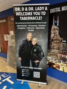 A standing banner features Dr. D and Dr. Lady, welcoming visitors to Tabernacle and listing church ministry focuses. Social media icons are at the bottom.