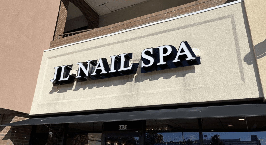 A storefront sign that reads "JL NAIL SPA" in large black letters above the entrance of a building.